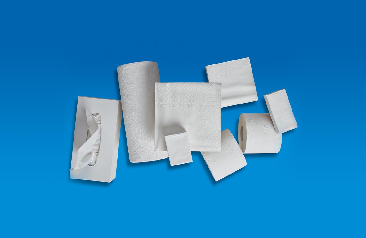 Toilettenpapier Küchentücher Taschentücher Servietten Kosmetiktücher optisch ansprechend auf einem blauen Untergrund angeordnet